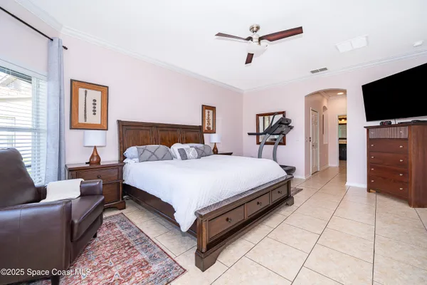 a bed room with a bed a television and a couch