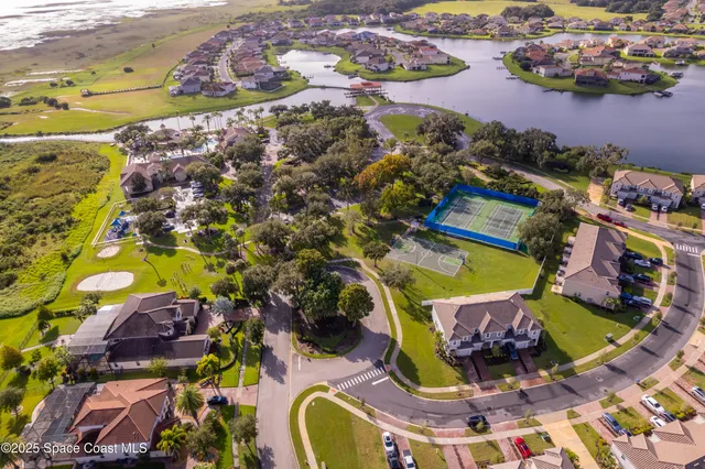 an aerial view of a house with a yard and lake view