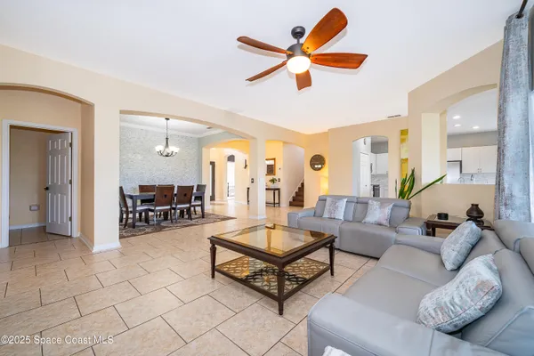 a living room with furniture and a chandelier