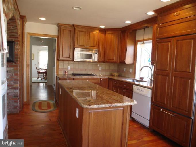 1912 Wilson Road White Hall, MD 21161 - Photo 16 of 29 a kitchen with stainless steel appliances granite countertop a refrigerator a stove and a sink with wooden cabinets