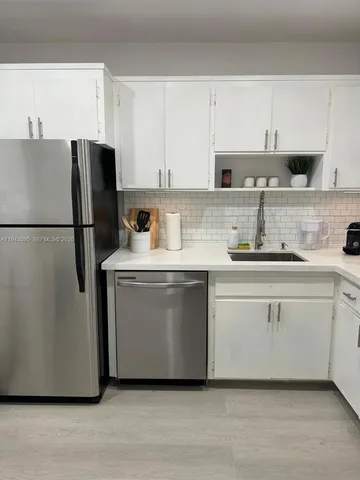 a kitchen with stainless steel appliances a refrigerator sink and cabinets