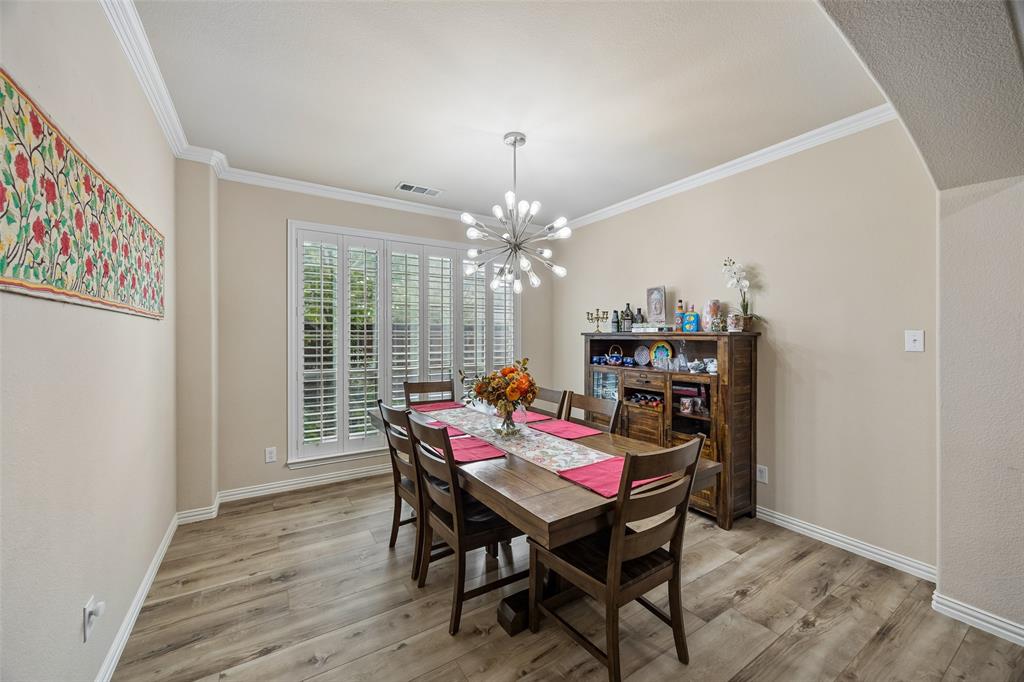 2865 Ridge View Road Frisco, TX 75034 - Photo 6 of 38 Wood-finish flooring with crisp white baseboards, crown molding, and a modern chandelier