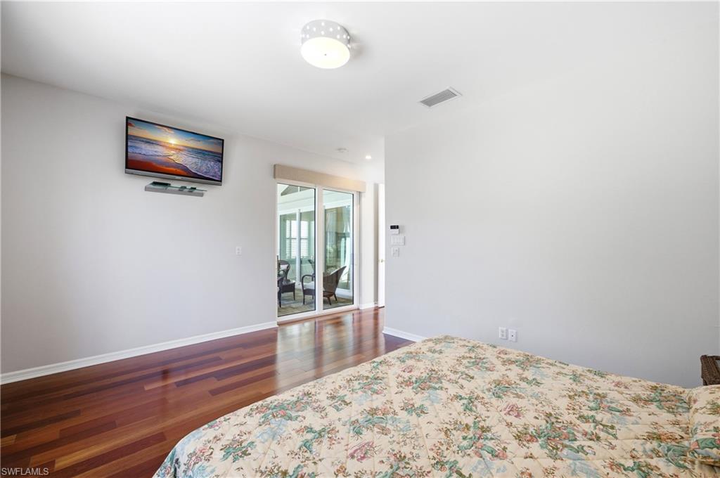 1960 Timarron Way Naples, FL 34109 - Photo 27 of 45 Master Bedroom Hardwood flooring extends throughout this room, complemented by white baseboards and walls