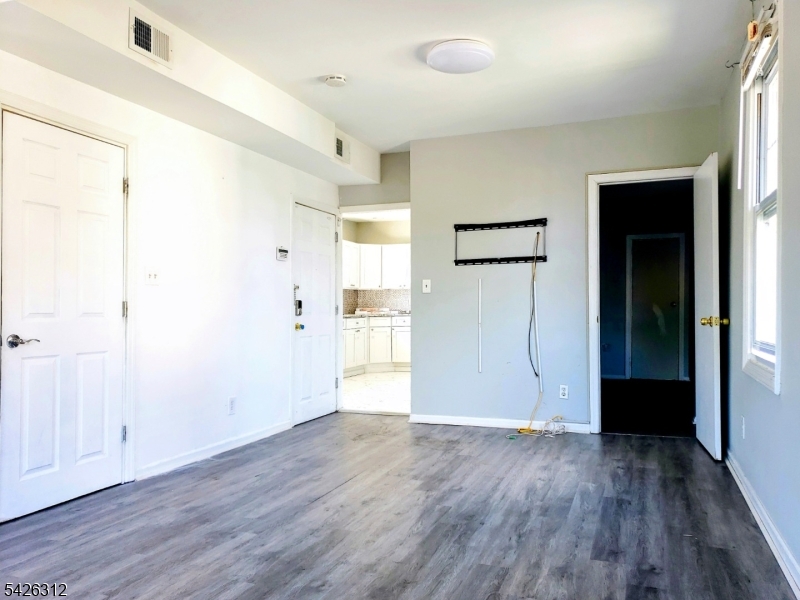 215 Lafayette Street Orange, NJ 07050 - Photo 4 of 14 an empty room with wooden floor and windows