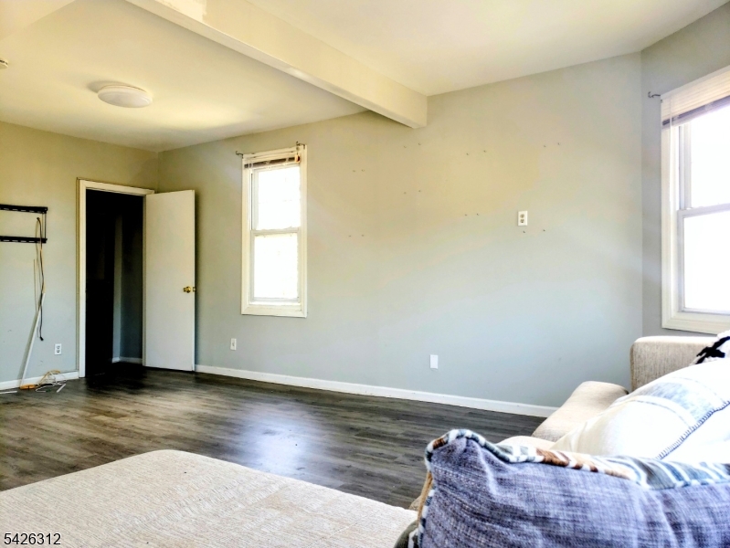 215 Lafayette Street Orange, NJ 07050 - Photo 5 of 14 a bed sitting in a bedroom next to a window and wooden floor