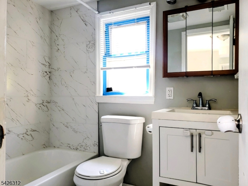 215 Lafayette Street Orange, NJ 07050 - Photo 6 of 14 a bathroom with a toilet a sink a bath tub and a window