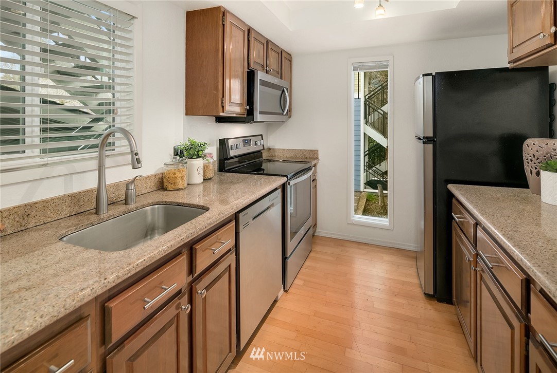 7577 Old Redmond Road, Unit 11 Redmond, WA 98052 - Photo 3 of 19 a kitchen with stainless steel appliances granite countertop a sink stove and refrigerator