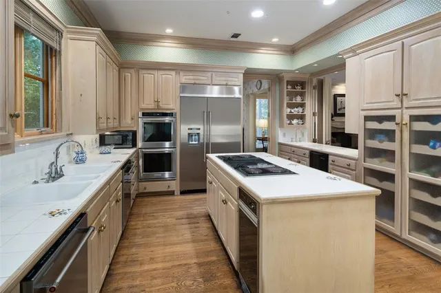 a kitchen with kitchen island stainless steel appliances a sink stove and refrigerator