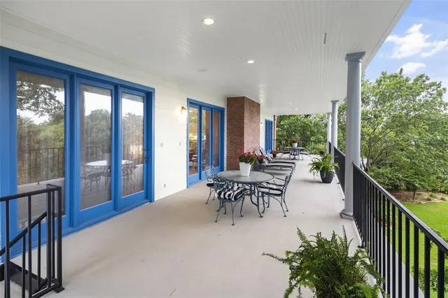 a view of a patio with table and chairs and potted plants with wooden floor