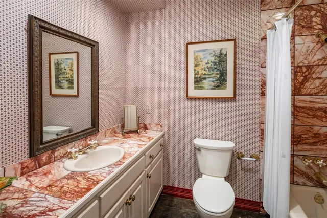 a bathroom with a granite countertop toilet a sink and a mirror