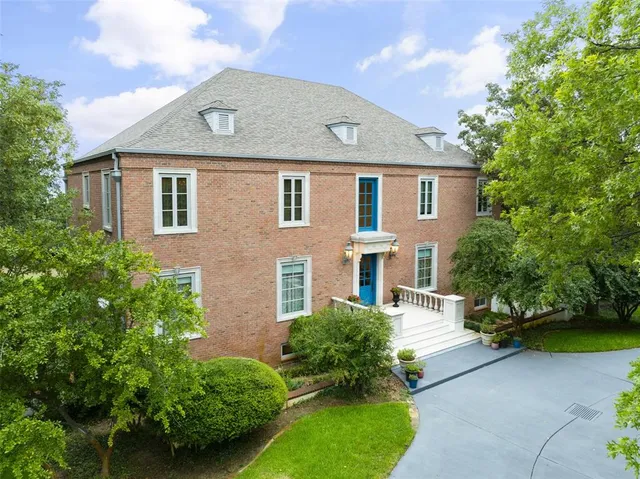 a front view of a house with a yard and potted plants