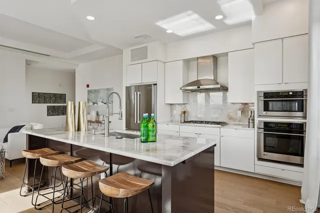 a kitchen with stainless steel appliances a table and chairs in it
