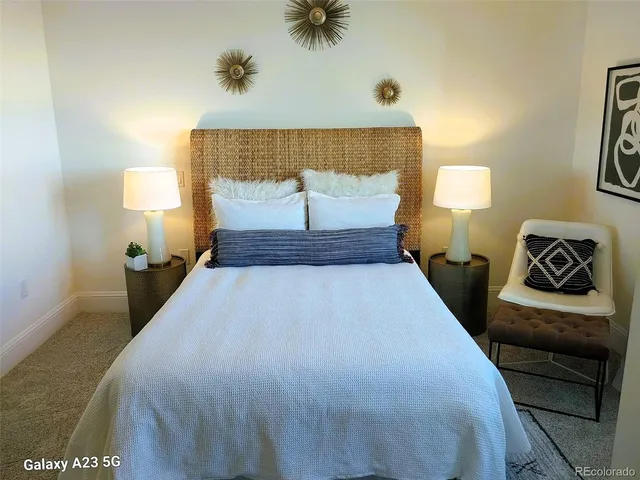 a bedroom with a bed and a lamp with the dresser