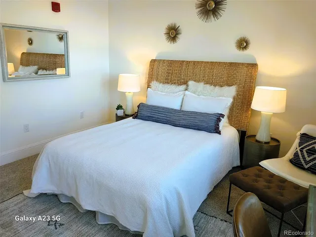 a bathroom with a granite countertop toilet sink and mirror