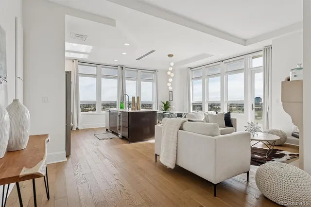 a living room with furniture a fireplace and a floor to ceiling window