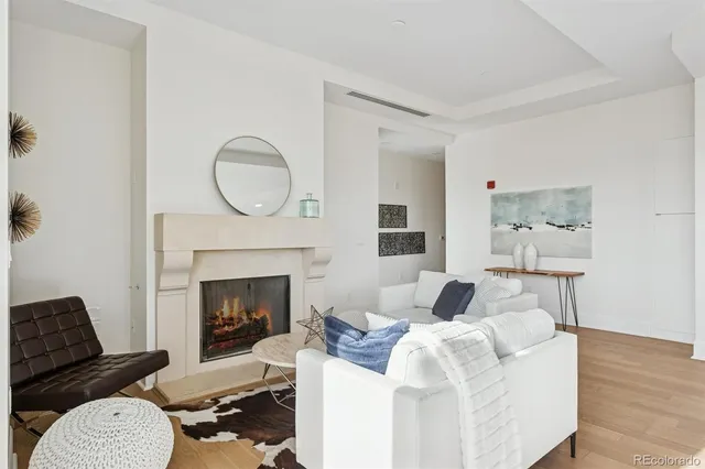 a living room with furniture a mirror and a fireplace