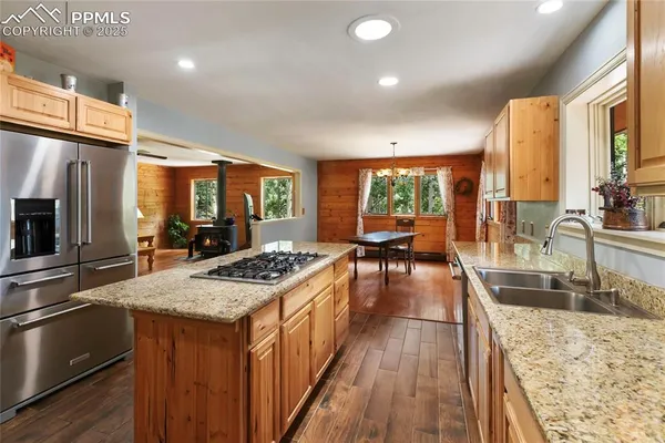 a kitchen with stainless steel appliances granite countertop sink stove and refrigerator