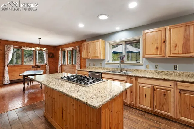 a kitchen with stainless steel appliances granite countertop a stove a sink dishwasher and cabinets with wooden floor