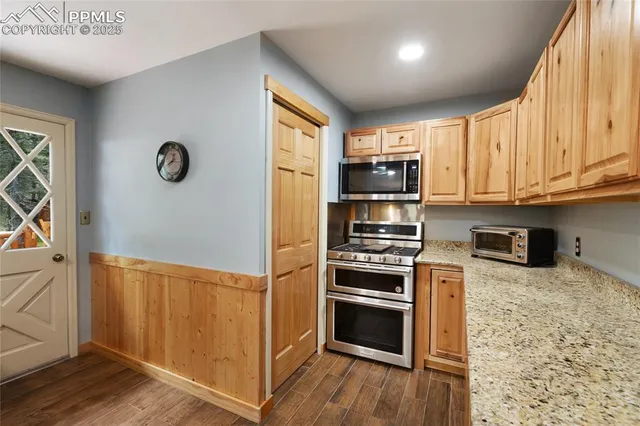 a kitchen with stainless steel appliances granite countertop a refrigerator sink and stove