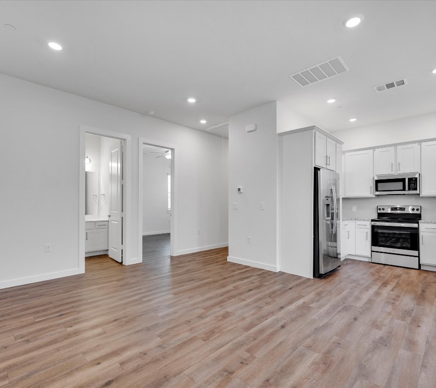 2703-406 Rockhill Road McKinney, TX 75072 - Photo 4 of 14 a view of a electric appliances in kitchen and an empty room with wooden floor