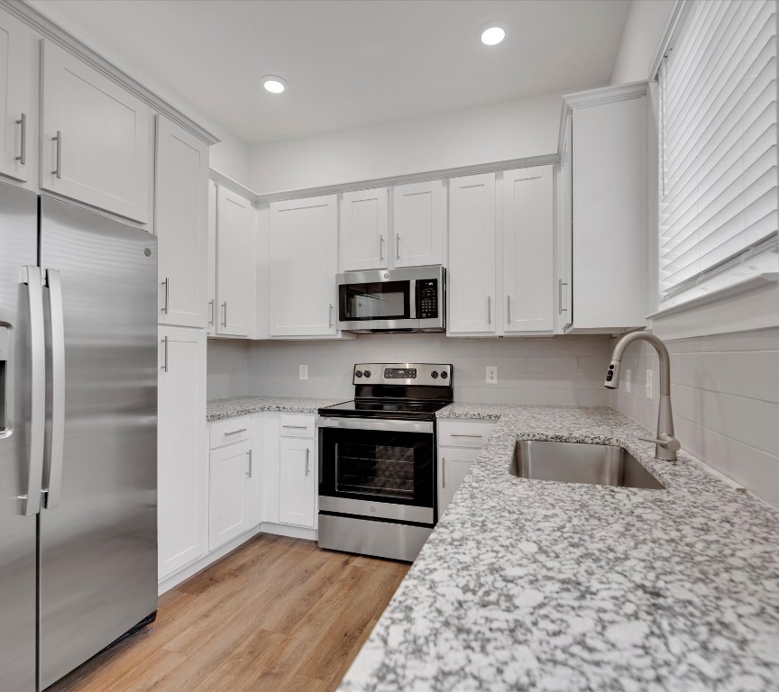 2703-406 Rockhill Road McKinney, TX 75072 - Photo 6 of 14 a kitchen with granite countertop a refrigerator stove and microwave
