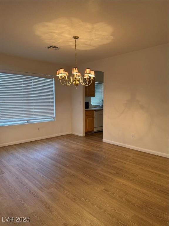 2733 Chokecherry Avenue Henderson, NV 89074 - Photo 11 of 26 Unfurnished dining area with dark wood-type flooring and a chandelier