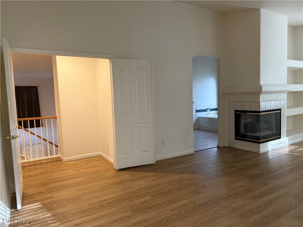 2733 Chokecherry Avenue Henderson, NV 89074 - Photo 15 of 26 Unfurnished living room with wood finished floors and a tile fireplace