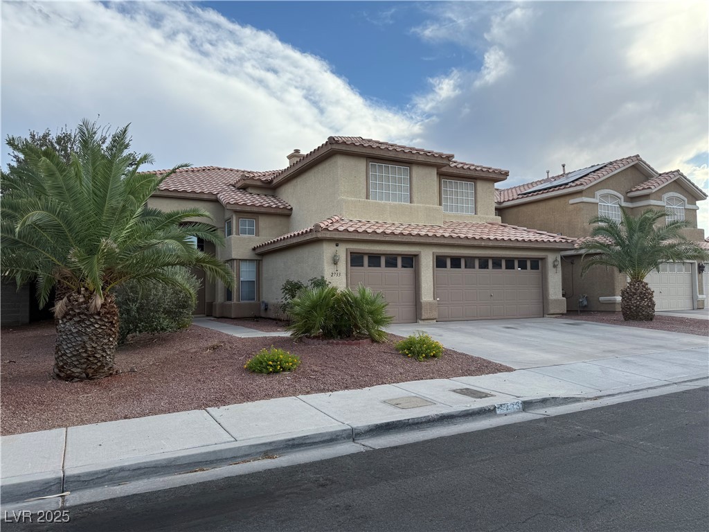 2733 Chokecherry Avenue Henderson, NV 89074 - Photo 2 of 26 Mediterranean / spanish-style house with stucco siding, a garage, driveway, and a tiled roof