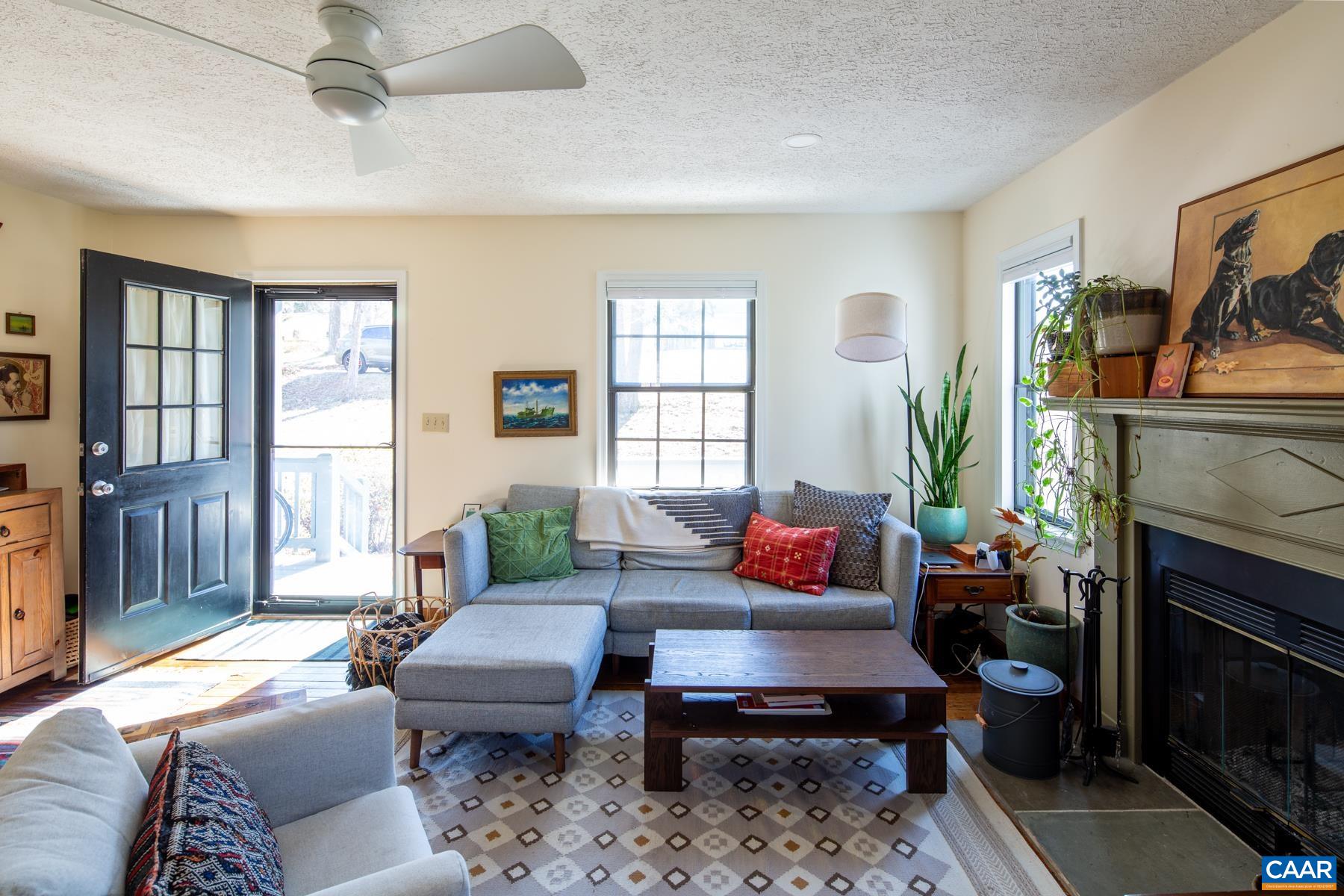 150 Buckingham Circle Charlottesville, VA 22903 - Photo 7 of 27 a living room with furniture a fireplace and a window