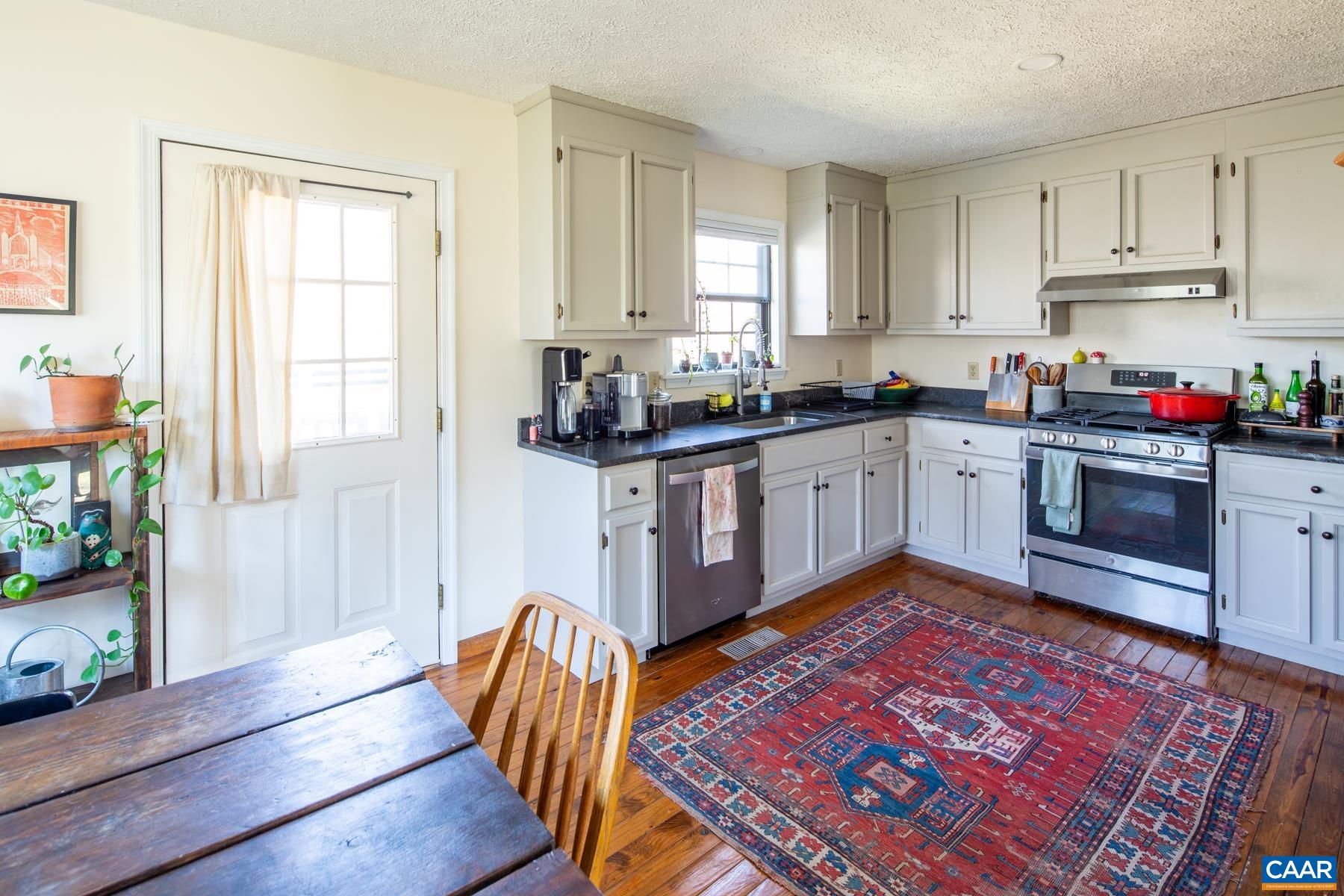150 Buckingham Circle Charlottesville, VA 22903 - Photo 9 of 27 a kitchen with stainless steel appliances granite countertop a stove top oven a sink dishwasher and cabinets with wooden floor