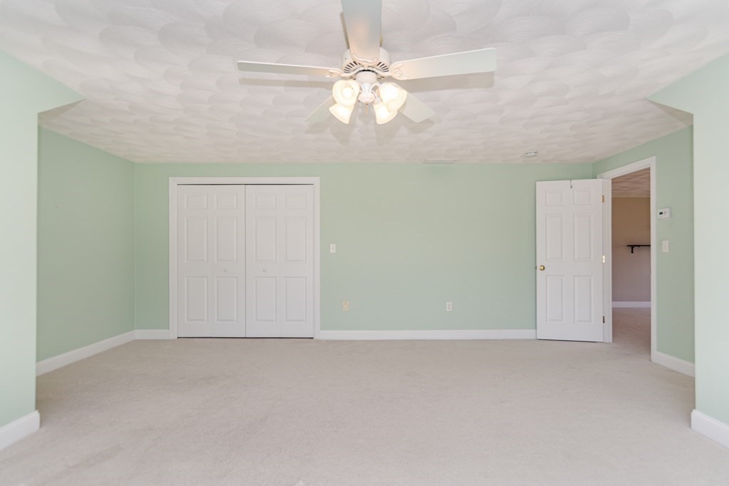 53 Baldwin Road, Unit 403 Billerica, MA 01821 - Photo 28 of 40 an empty room with a chandelier fan and windows
