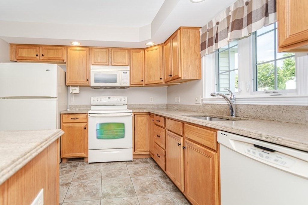 53 Baldwin Road, Unit 403 Billerica, MA 01821 - Photo 10 of 40 a kitchen with stainless steel appliances granite countertop a sink and a stove