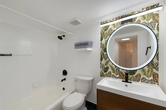 a bathroom with a sink mirror vanity and toilet