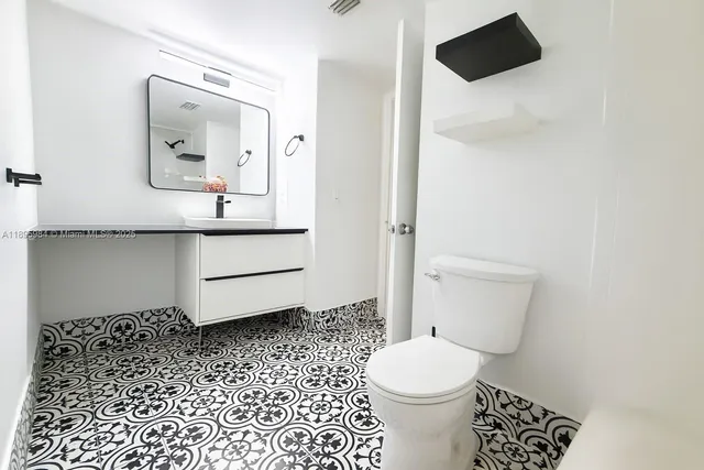 a bathroom with a toilet a sink and mirror