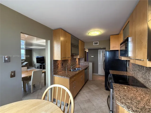 a kitchen with stainless steel appliances granite countertop a sink a stove and refrigerator