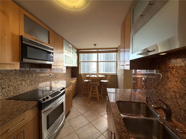 a kitchen with stainless steel appliances granite countertop a sink stove and microwave