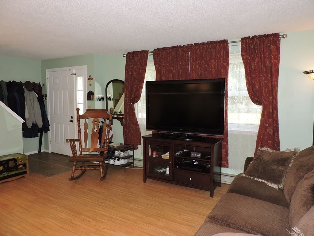 2 Hall Road Webster, MA 01570 - Photo 13 of 42 a living room with furniture a flat screen tv and gym equipment