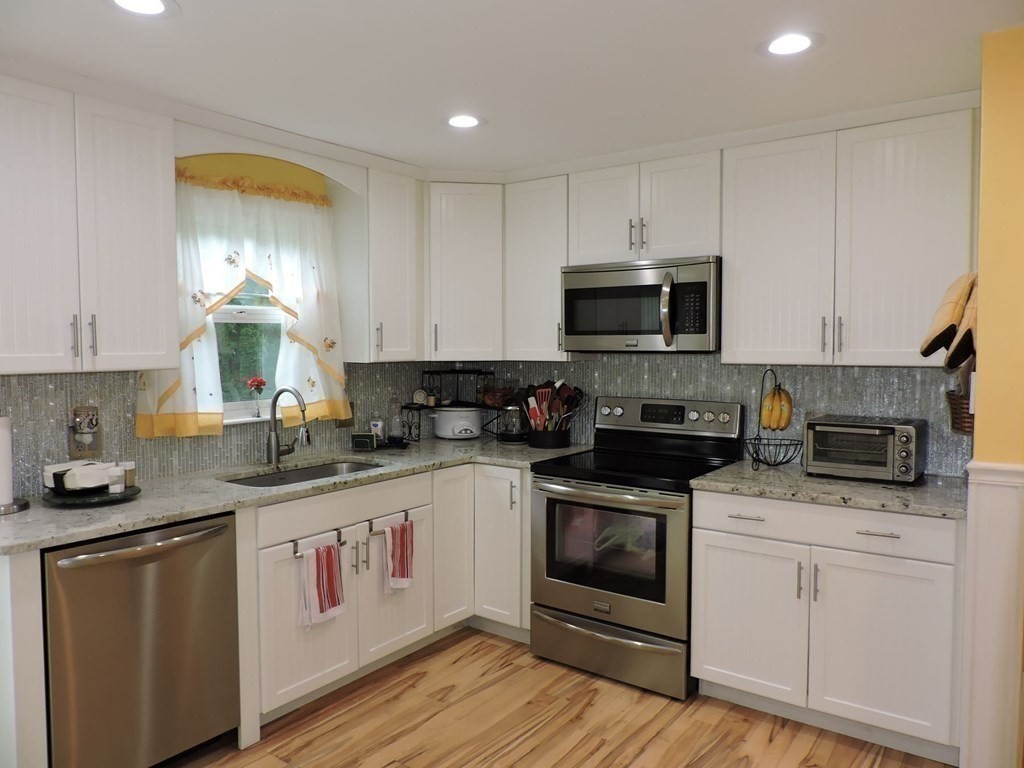 2 Hall Road Webster, MA 01570 - Photo 9 of 42 a kitchen with granite countertop white cabinets and white appliances