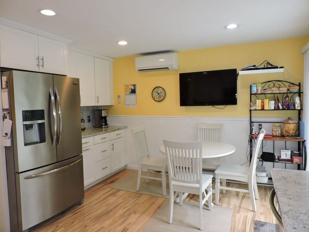 2 Hall Road Webster, MA 01570 - Photo 10 of 42 a kitchen with stainless steel appliances a refrigerator a stove a dining table and chairs with wooden floor