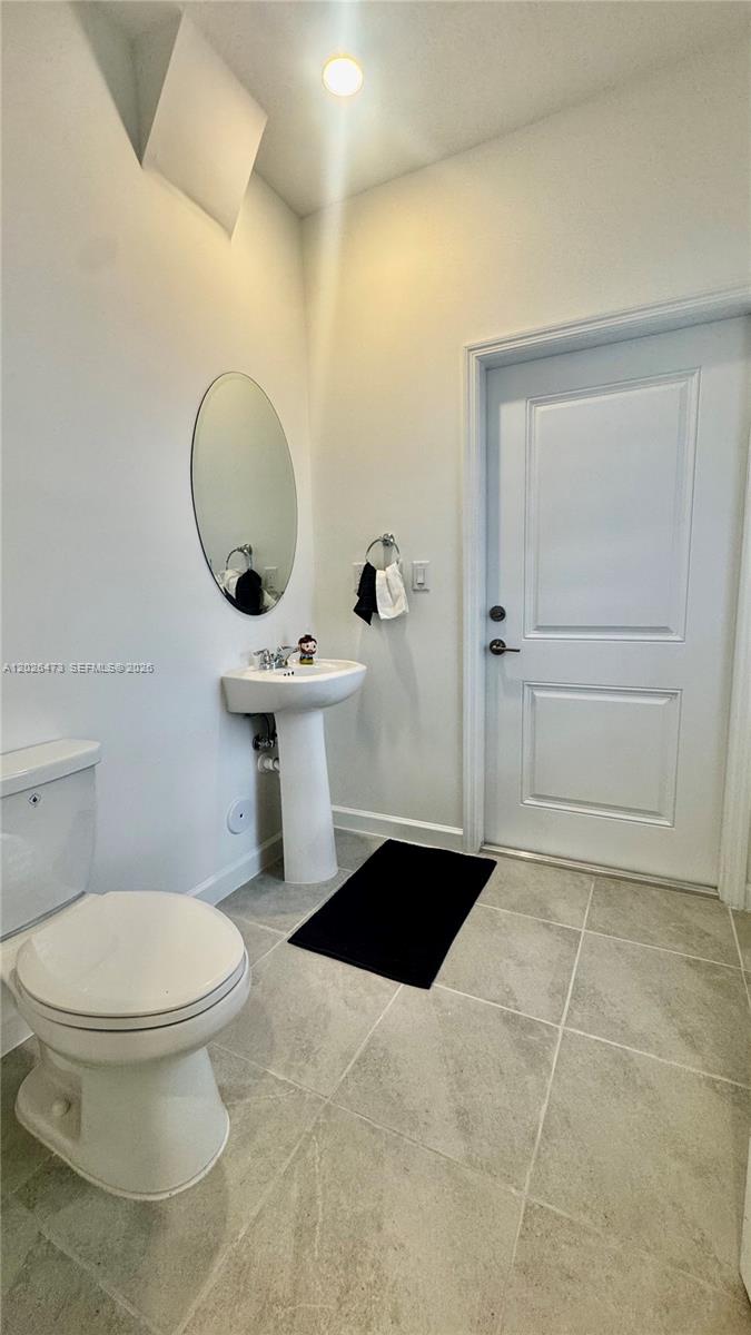 19479 Southwest 340th Street, Unit 1 Homestead, FL 33034 - Photo 33 of 58 a bathroom with a toilet a sink and mirror