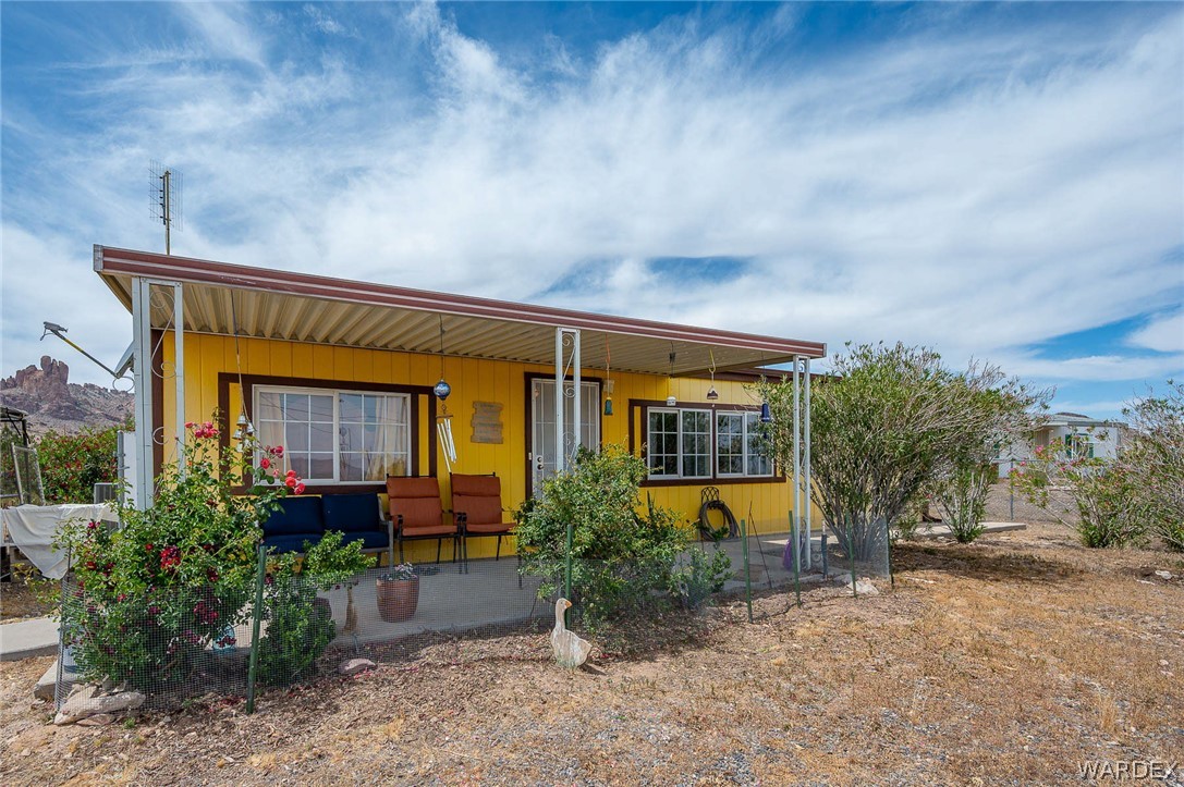2465 Egar Road Golden Valley, AZ 86413 - Photo 12 of 98 The property features a yellow exterior and a covered porch