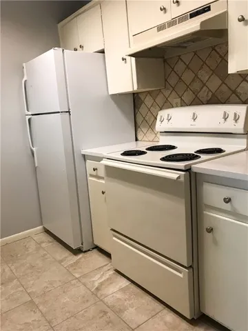 a close view of a sink a faucet cabinets and appliances