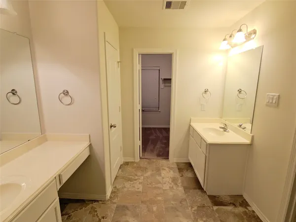 a bathroom with a sink and mirror with bathtub