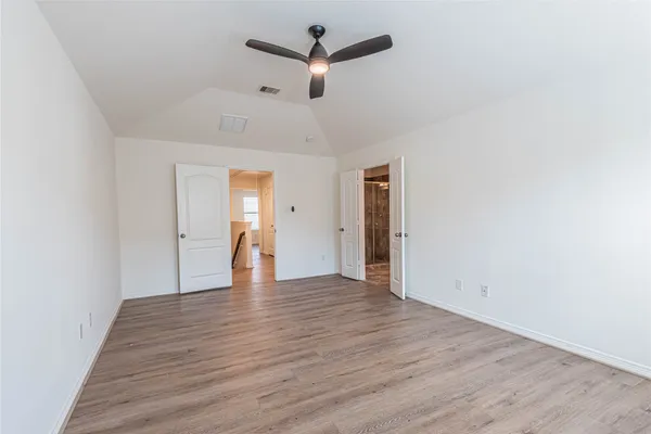 a view of empty room with wooden floor