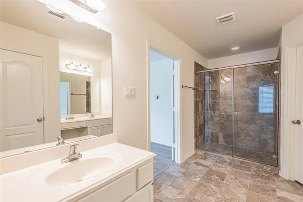 a bathroom with a sink shower and a mirror