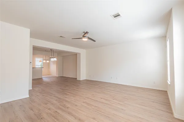 a view of an empty room with wooden floor