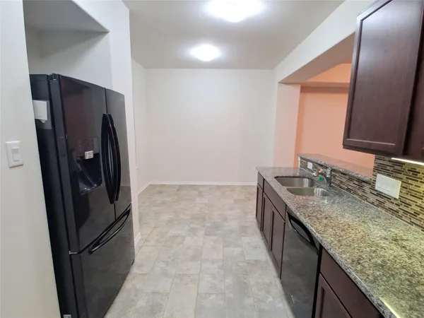 a kitchen with stainless steel appliances granite countertop a refrigerator and a sink