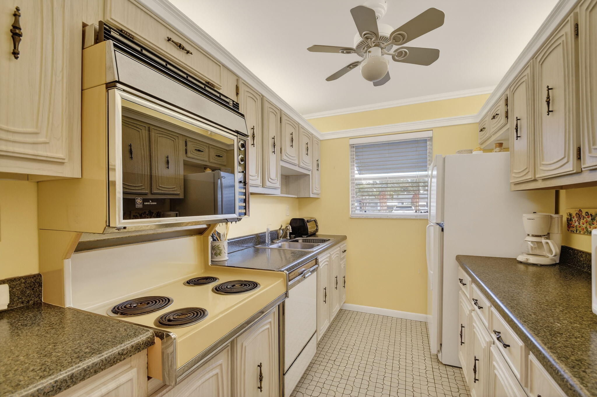 615 High Point Drive, Unit C Delray Beach, FL 33445 - Photo 17 of 48 a kitchen with a stove a sink and a refrigerator
