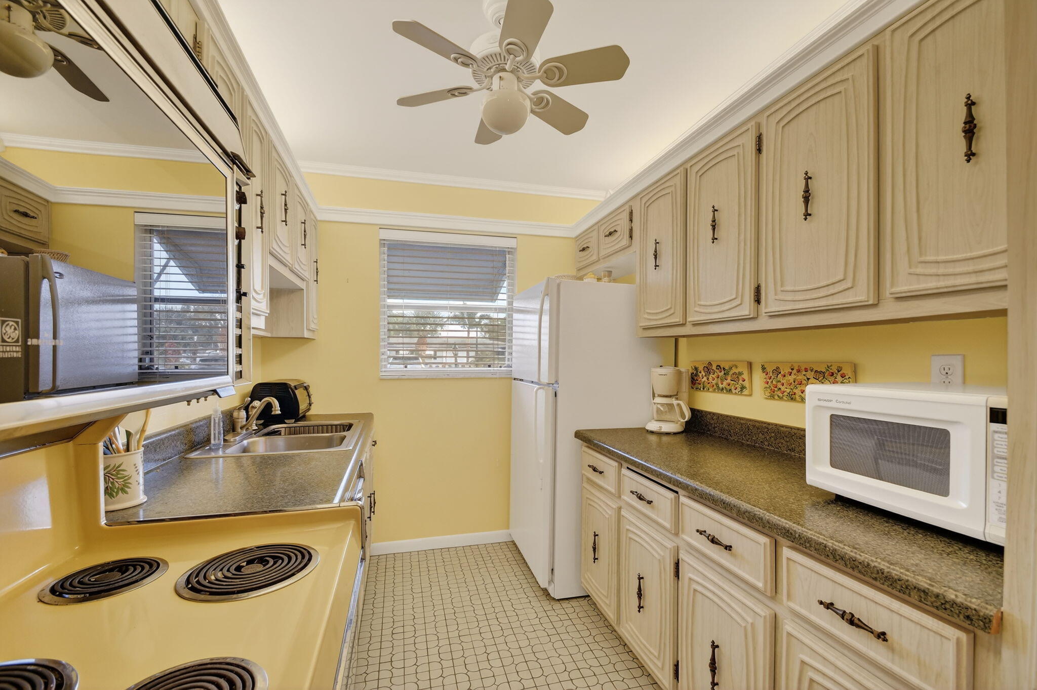 615 High Point Drive, Unit C Delray Beach, FL 33445 - Photo 18 of 48 a kitchen with a sink stove and microwave