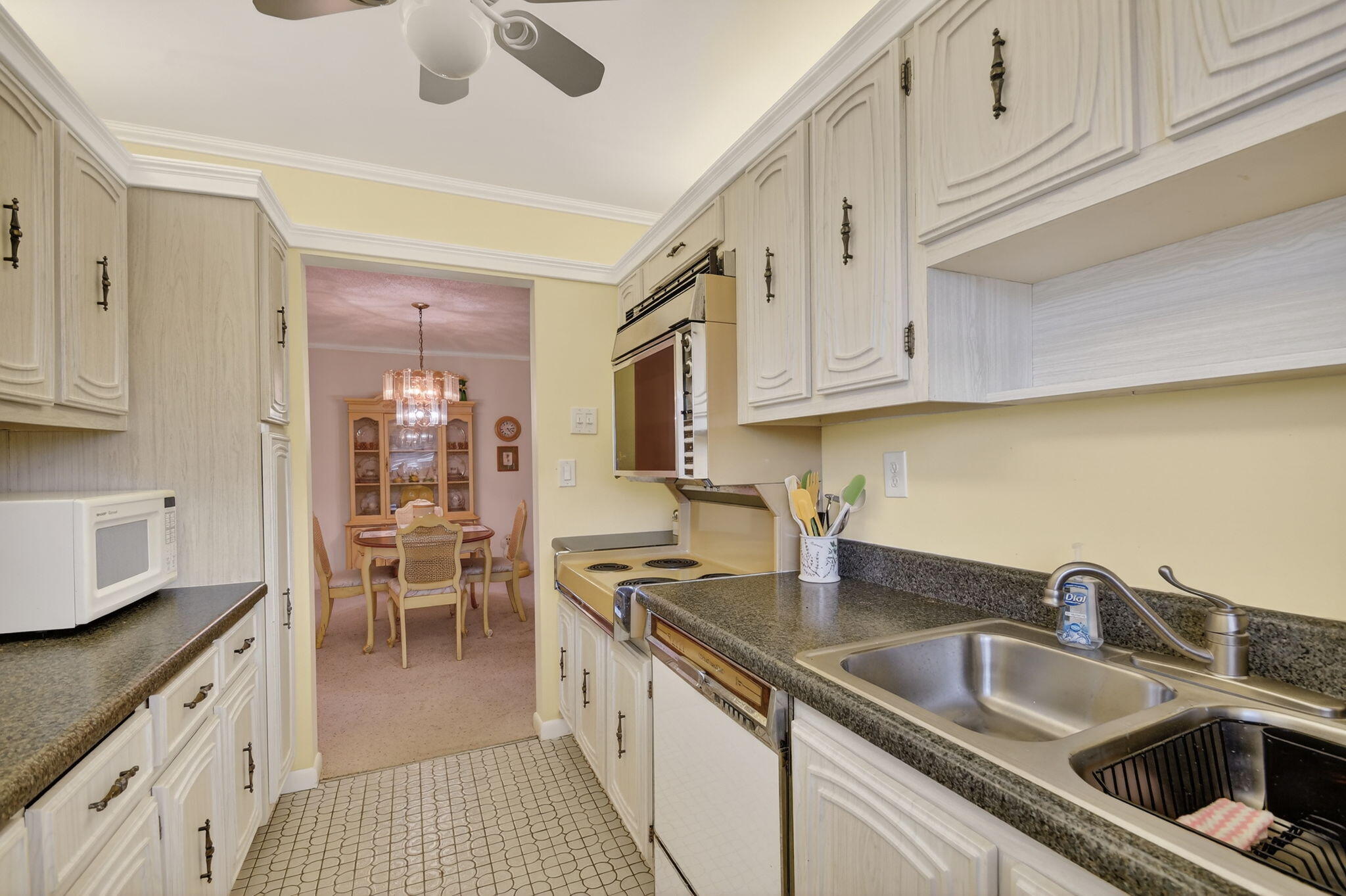 615 High Point Drive, Unit C Delray Beach, FL 33445 - Photo 19 of 48 a kitchen with granite countertop a sink and cabinets